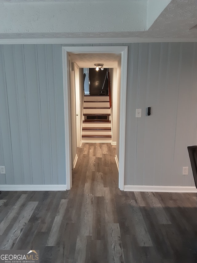 hallway with a textured ceiling and dark hardwood / wood-style floors