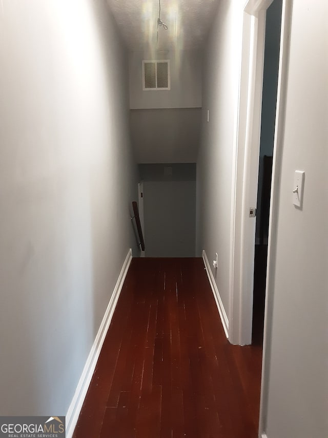 corridor with dark hardwood / wood-style flooring