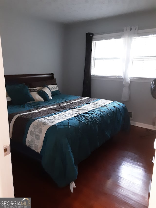 bedroom with dark hardwood / wood-style flooring