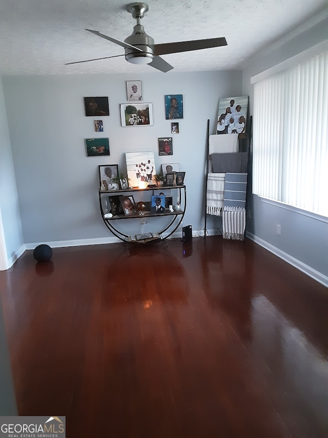 interior space featuring a textured ceiling, ceiling fan, and wood-type flooring