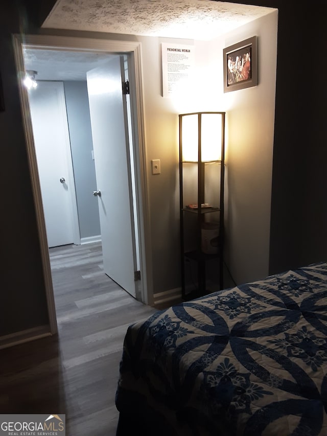 bedroom featuring a textured ceiling and hardwood / wood-style flooring