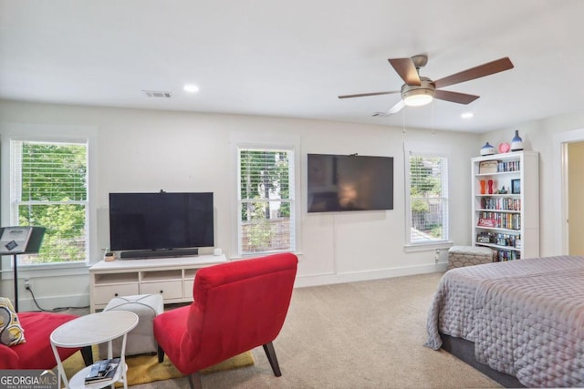 carpeted bedroom with multiple windows and ceiling fan