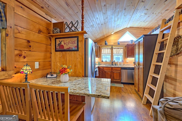 kitchen with light stone countertops, wood ceiling, stainless steel appliances, lofted ceiling, and wood walls