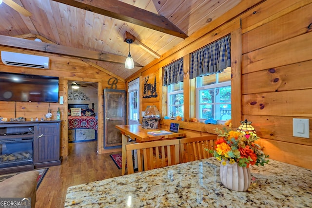 dining room featuring hardwood / wood-style floors, a wall mounted AC, wood walls, ceiling fan, and vaulted ceiling with beams