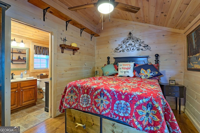 bedroom featuring light hardwood / wood-style floors, connected bathroom, ceiling fan, and vaulted ceiling with beams