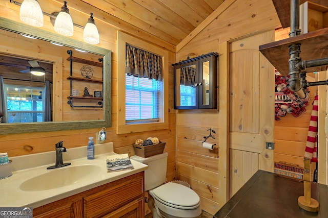 bathroom with toilet, wooden walls, vanity, wood ceiling, and lofted ceiling