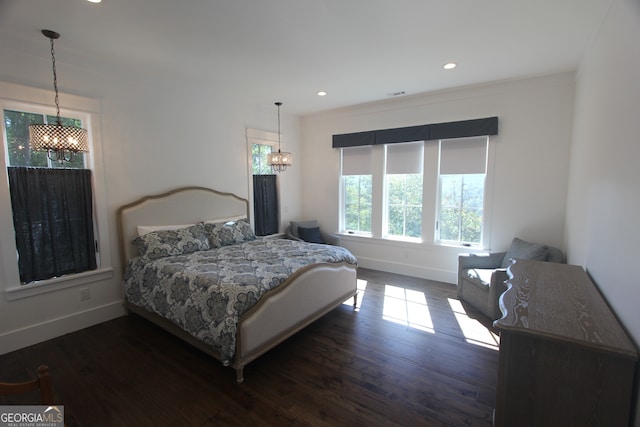 bedroom featuring an inviting chandelier and dark hardwood / wood-style flooring