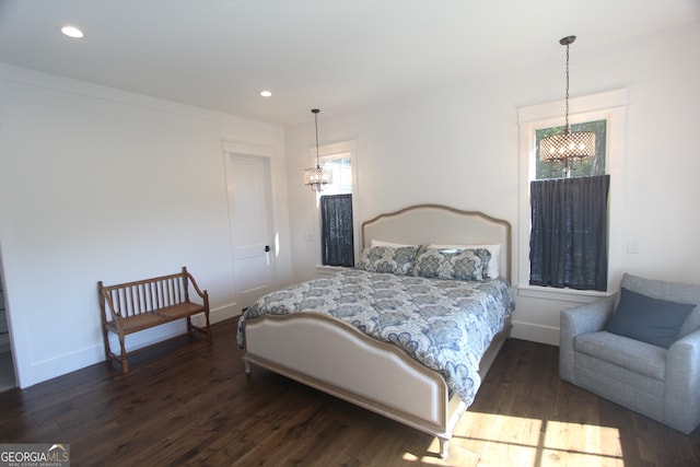 bedroom featuring an inviting chandelier and dark hardwood / wood-style floors