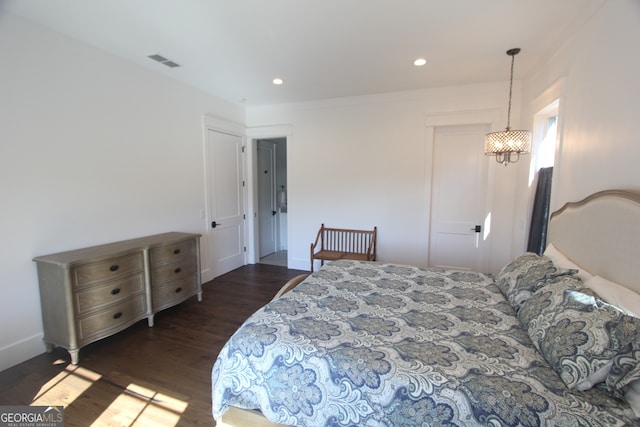 bedroom featuring dark wood-type flooring and a chandelier