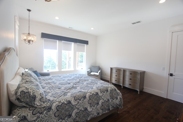 bedroom featuring dark hardwood / wood-style floors and a chandelier