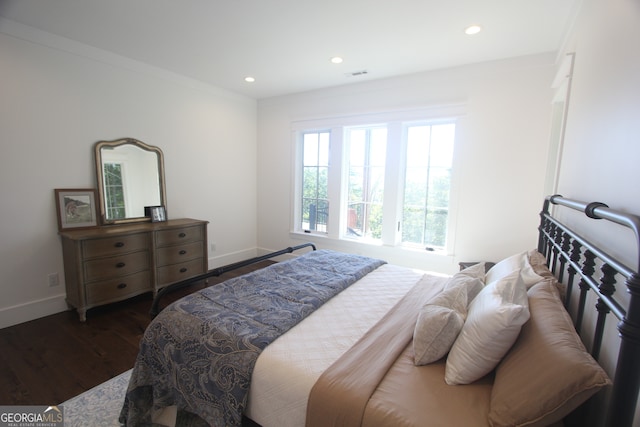 bedroom featuring crown molding and dark hardwood / wood-style flooring