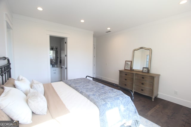 bedroom featuring ornamental molding, dark wood-type flooring, and ensuite bathroom