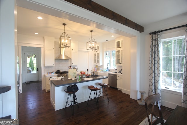 kitchen with white cabinets, a center island, a kitchen bar, and stainless steel dishwasher