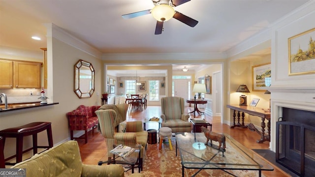 living room featuring crown molding, ceiling fan, and wood-type flooring