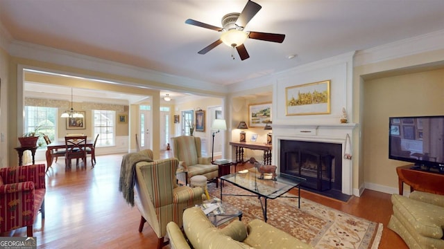 living room featuring ornamental molding, ceiling fan, and light hardwood / wood-style floors