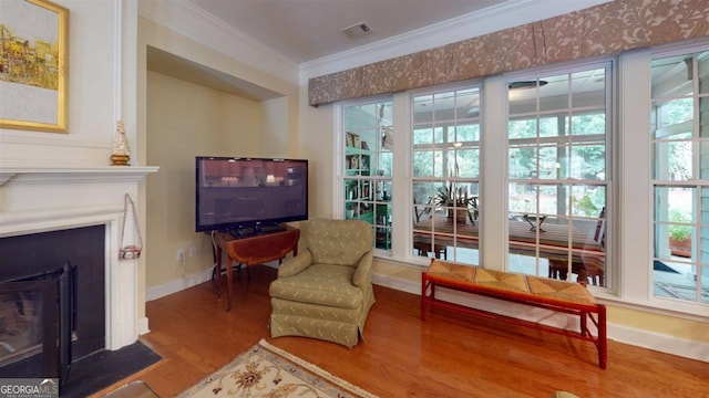 sitting room with ornamental molding and hardwood / wood-style flooring