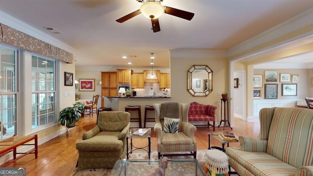 living room featuring ornamental molding, ceiling fan, and light hardwood / wood-style floors