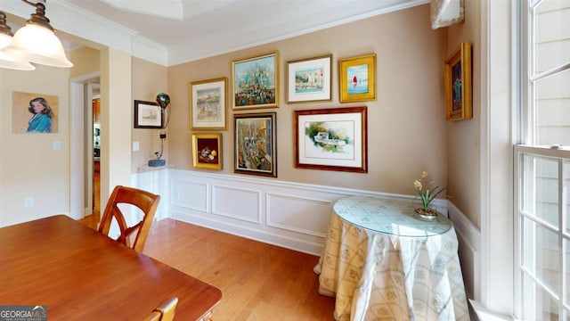 dining space with light hardwood / wood-style flooring and ornamental molding