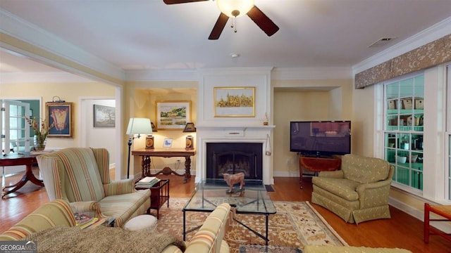 living room featuring crown molding, hardwood / wood-style floors, and ceiling fan