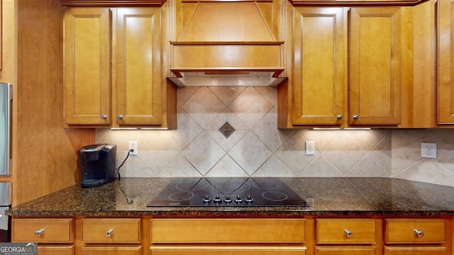 kitchen featuring black electric stovetop, dark stone countertops, and tasteful backsplash