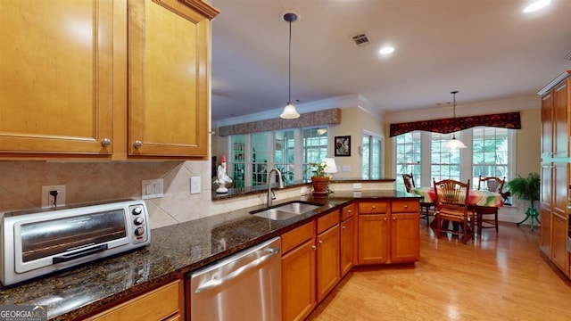 kitchen featuring stainless steel dishwasher, a healthy amount of sunlight, kitchen peninsula, and sink