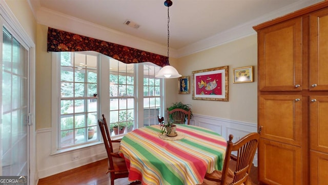 dining area featuring crown molding, plenty of natural light, and hardwood / wood-style floors