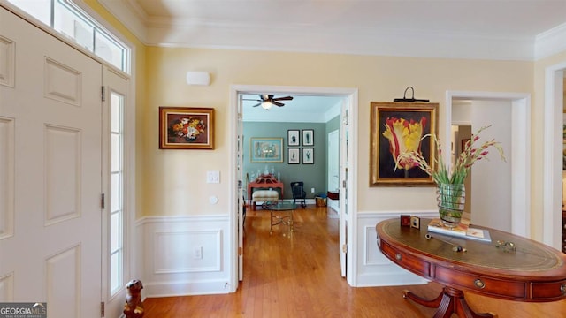 foyer with ceiling fan, crown molding, and light hardwood / wood-style flooring