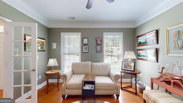 living area featuring crown molding, ceiling fan, and wood-type flooring