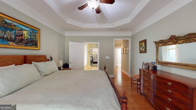 bedroom with ceiling fan, hardwood / wood-style flooring, a raised ceiling, and crown molding