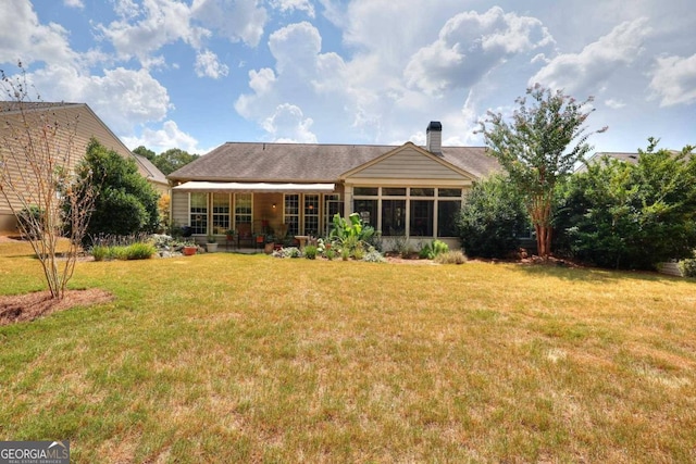 back of property featuring a lawn and a sunroom