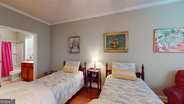 bedroom with crown molding, dark wood-type flooring, and ensuite bath