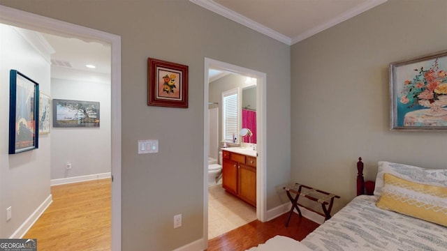 bedroom featuring crown molding, hardwood / wood-style flooring, and ensuite bathroom