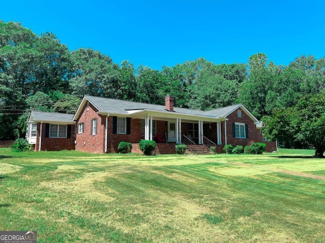 ranch-style home featuring a front lawn and covered porch