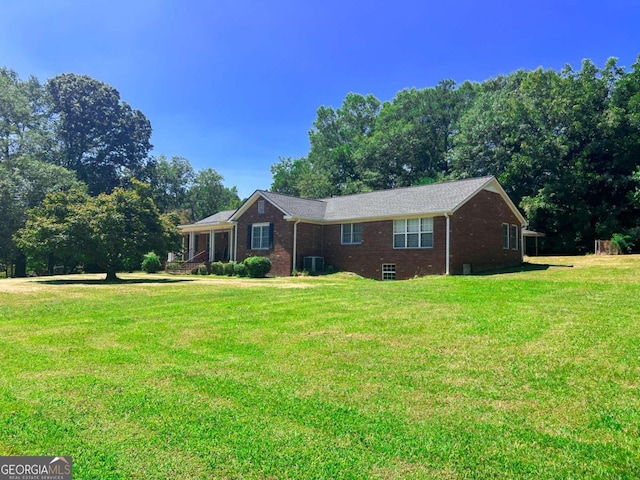 ranch-style home with central AC, brick siding, and a front yard