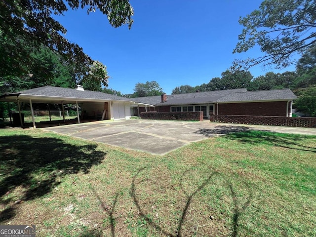 view of front of property featuring an attached carport, concrete driveway, and a front yard