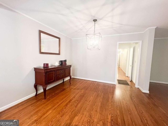 dining space featuring crown molding, baseboards, and wood finished floors