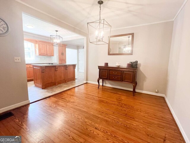 dining area featuring a chandelier, crown molding, and light hardwood / wood-style flooring