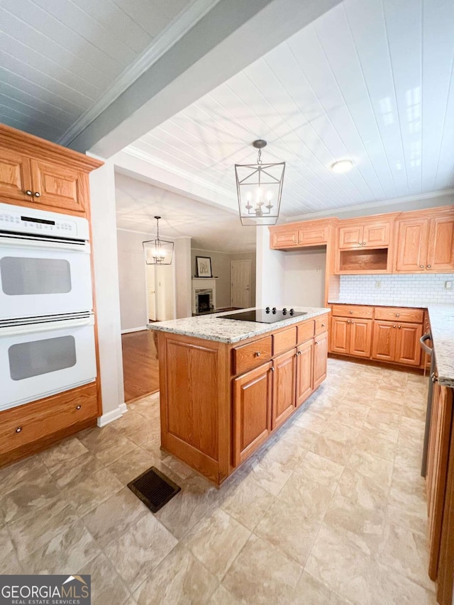 kitchen featuring light stone countertops, white double oven, and an inviting chandelier