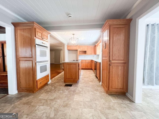 kitchen with crown molding, double oven, pendant lighting, a kitchen island, and decorative backsplash