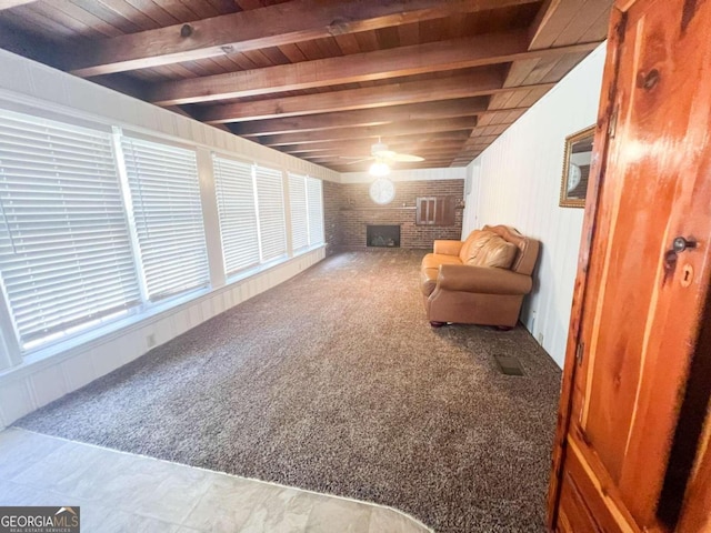 sitting room featuring beamed ceiling, a fireplace, carpet floors, wood ceiling, and ceiling fan