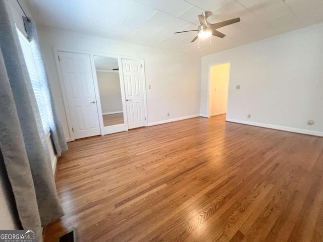 interior space featuring light wood-type flooring, baseboards, visible vents, and a ceiling fan