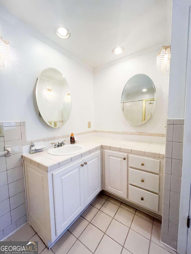 bathroom with tile walls, tile patterned flooring, and vanity