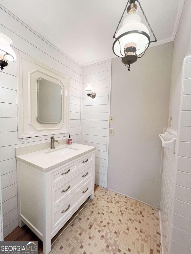 bathroom with wood walls, vanity, and crown molding