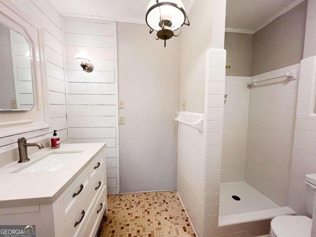 bathroom featuring toilet, tile patterned floors, ornamental molding, vanity, and a shower