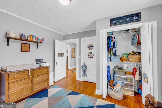 bedroom with a closet, light hardwood / wood-style floors, and a textured ceiling