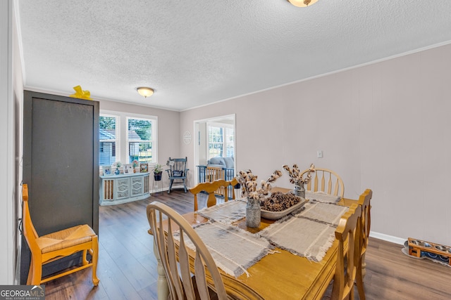 dining area featuring crown molding, a textured ceiling, and hardwood / wood-style floors