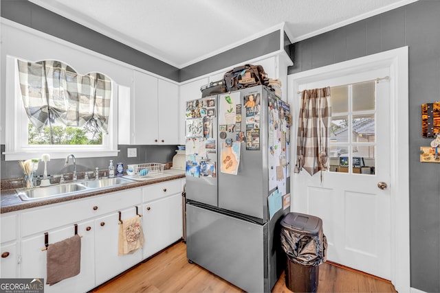 kitchen featuring crown molding, stainless steel fridge, sink, and light hardwood / wood-style floors