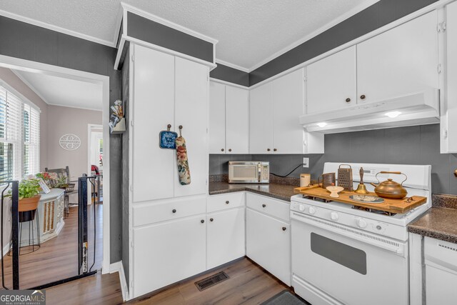 kitchen with crown molding, dark wood-type flooring, white cabinets, and white gas range