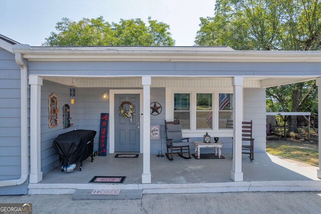 view of exterior entry featuring covered porch