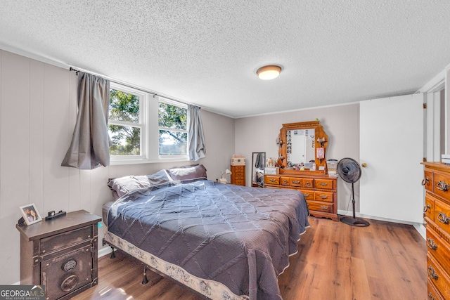 bedroom with hardwood / wood-style flooring and a textured ceiling